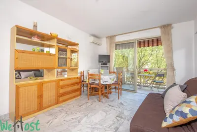 a living room with a couch and a dining room at Studio - Palais des Festivals in Cannes