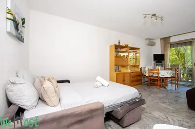 a bedroom with a bed and a living room at Studio - Palais des Festivals in Cannes