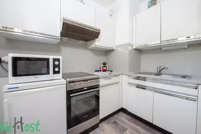 a kitchen with white cabinets and a microwave at Studio - Palais des Festivals in Cannes