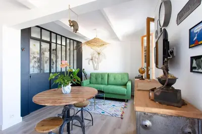 a living room with a table and a green couch at SAVANE -Studio cosy proche Croisette-Classé 2 Etoiles in Cannes