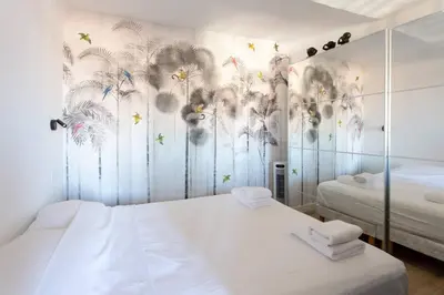 a bedroom with two beds and a mural of flowers at SAVANE -Studio cosy proche Croisette-Classé 2 Etoiles in Cannes