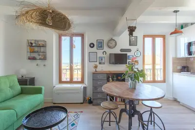 a living room with a green couch and a table at SAVANE -Studio cosy proche Croisette-Classé 2 Etoiles in Cannes