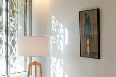 a lamp with a white lamp shade next to a window at Garden level Croisette sea view with garage in Cannes