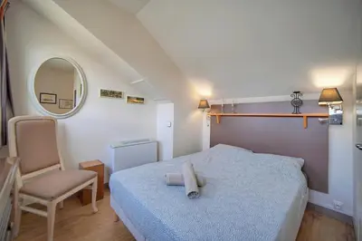 a bedroom with a bed and a chair and a mirror at Edouard - Piscine-Parking - VCA in Cannes