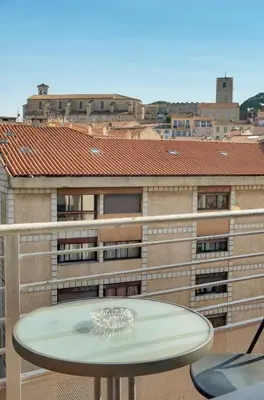 a table on a balcony with a view of a building at Edouard - Piscine-Parking - VCA in Cannes