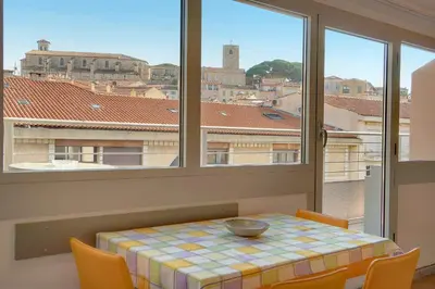 a table and chairs in a room with windows at Edouard - Piscine-Parking - VCA in Cannes