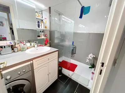 a white bathroom with a sink and a shower at Cosy 1 bedroom Republique 236 in Cannes