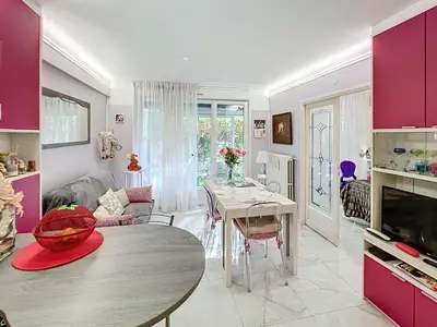 a kitchen and living room with a table and purple cabinets at Cosy 1 bedroom Republique 236 in Cannes