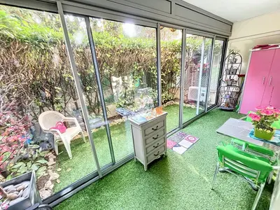 a room with green carpeted floors and sliding glass doors at Cosy 1 bedroom Republique 236 in Cannes