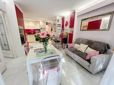 a living room with a couch and a table with flowers at Cosy 1 bedroom Republique 236 in Cannes