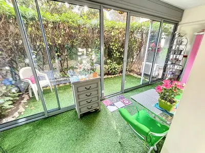 a room with a green carpeted floor and windows at Cosy 1 bedroom Republique 236 in Cannes