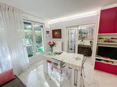 a dining room with a table with flowers on it at Cosy 1 bedroom Republique 236 in Cannes