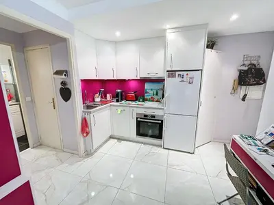 a kitchen with white cabinets and pink walls at Cosy 1 bedroom Republique 236 in Cannes