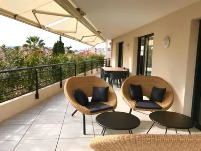 a balcony with chairs and tables and a table at superbe 3 chambres proche palais et croisette dag13 in Cannes