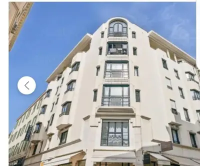 a tall white building with a clock on it at Jo Malone in Cannes