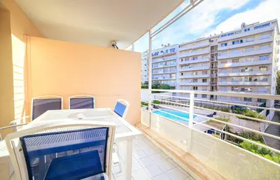 a balcony with a table and a laptop on it at RIO - 200 m plages - App 6pers- climatisé, terrasse, piscine, parking in Cannes