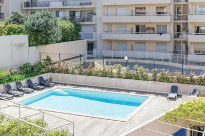 an empty swimming pool in front of a building at RIO - 200 m plages - App 6pers- climatisé, terrasse, piscine, parking in Cannes