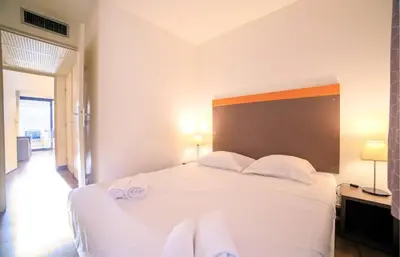 a bedroom with a white bed with towels on it at RIO - 200 m plages - App 6pers- climatisé, terrasse, piscine, parking in Cannes