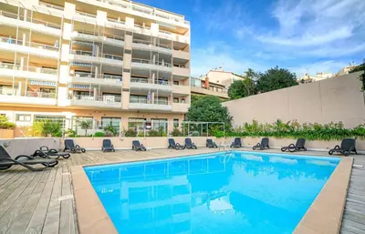 a swimming pool in front of a building at RIO - 200 m plages - App 6pers- climatisé, terrasse, piscine, parking in Cannes