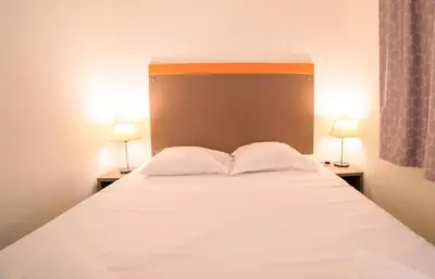 a bedroom with a large white bed with two lamps at RIO - 200 m plages - App 6pers- climatisé, terrasse, piscine, parking in Cannes
