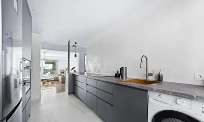 a white kitchen with a sink and a washing machine at Le Royal in Cannes