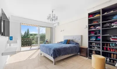a bedroom with a bed and a balcony at Le Royal in Cannes