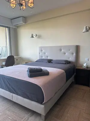 a bedroom with a large bed with a large headboard at Le Royal in Cannes