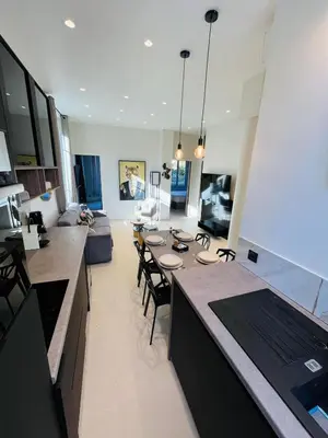 a kitchen and living room with a table and chairs at 3 pièces en cœur de cannes in Cannes