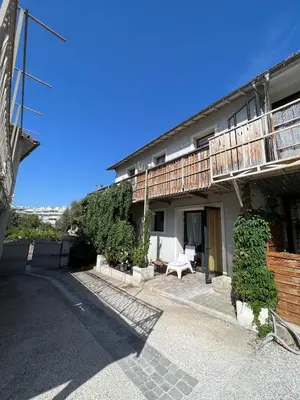 a building with a balcony and a bench in front of it at Charmant duplex proche de Cannes centre et à 2min à pied de la mer in Cannes