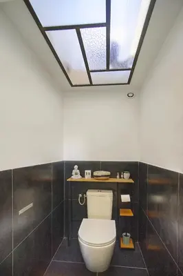 a bathroom with a white toilet and a skylight at Charmant duplex proche de Cannes centre et à 2min à pied de la mer in Cannes