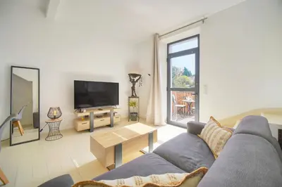 a living room with a couch and a tv at Charmant duplex proche de Cannes centre et à 2min à pied de la mer in Cannes