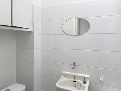 a white bathroom with a sink and a mirror at Stunning sea view on La Croisette in Cannes