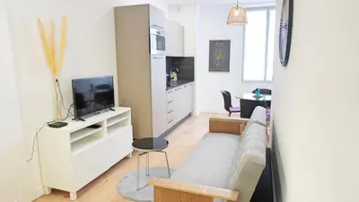 a living room with a couch and a tv at Proche Carlton & Croisette, Appartement 202 - Palmazur Vacances in Cannes