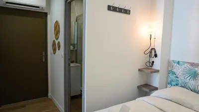 a bedroom with a bed and a door to a bathroom at Proche Carlton & Croisette, Appartement 202 - Palmazur Vacances in Cannes