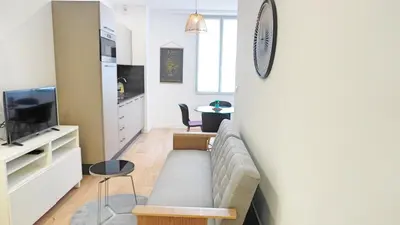 a living room with a couch and a table at Proche Carlton & Croisette, Appartement 202 - Palmazur Vacances in Cannes