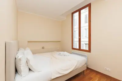 a white bed in a room with a window at L'Azuréa - Centre - Plage - Wifi - Climatisation in Cannes