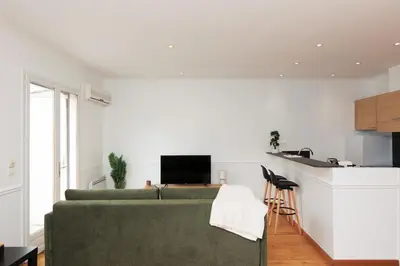 a living room with a green couch and a kitchen at L'Azuréa - Centre - Plage - Wifi - Climatisation in Cannes