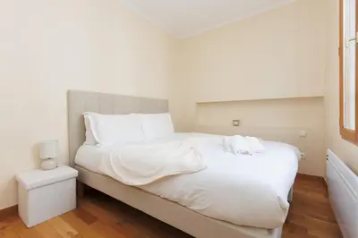 a white bedroom with a large bed with white sheets at L'Azuréa - Centre - Plage - Wifi - Climatisation in Cannes