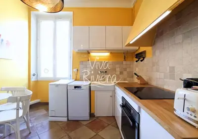 a kitchen with white appliances and yellow walls at Viva Riviera 5 Rue Florian in Cannes