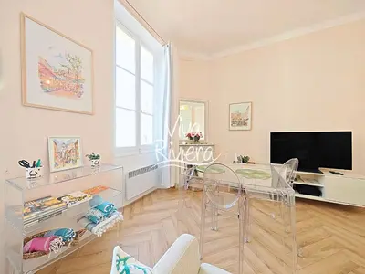 a dining room with a glass table and a television at Viva Riviera 5 Rue Florian in Cannes