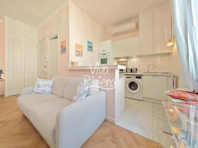 a living room with a couch and a kitchen at Viva Riviera 5 Rue Florian in Cannes