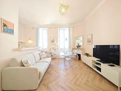a living room with a couch and a tv at Viva Riviera 5 Rue Florian in Cannes