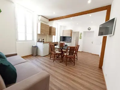 a living room with a table and chairs and a kitchen at Viva Riviera 6 Rue Commandant André in Cannes