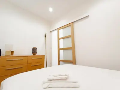 a white bedroom with a bed and a dresser at Viva Riviera 6 Rue Commandant André in Cannes