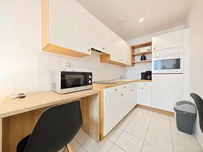 a kitchen with white cabinets and a counter with a microwave at Viva Riviera 6 Rue Commandant André in Cannes