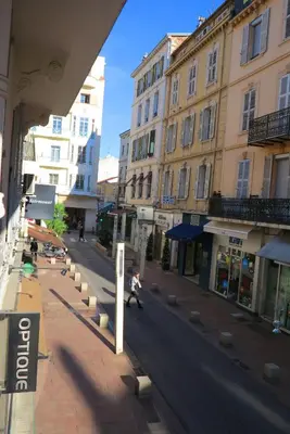 a person walking down a city street with buildings at Viva Riviera 6 Rue Commandant André in Cannes
