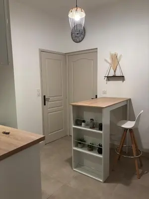 a kitchen with a counter and a table and a stool at Cosy Apartment in Cannes, AC, WiFi, 15min Palais in Cannes