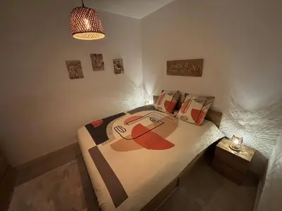 a bedroom with a bed with a painting on it at Cosy Apartment in Cannes, AC, WiFi, 15min Palais in Cannes