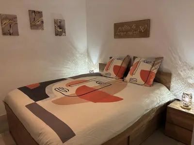 a bedroom with a bed with a painting on it at Cosy Apartment in Cannes, AC, WiFi, 15min Palais in Cannes