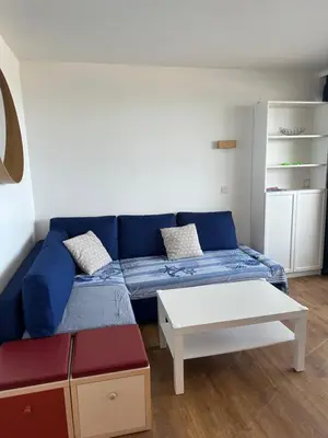 a living room with a blue couch and a table at Sisley 1061 - F2 Terrasse avec vue mer in Cannes